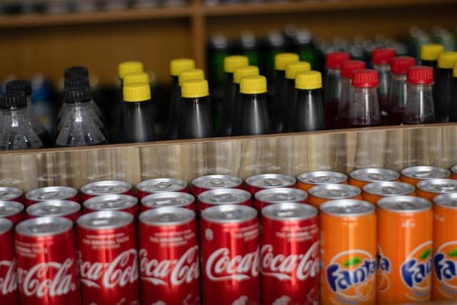 rows of coca-cola, orange fanta, and other bottled beverages